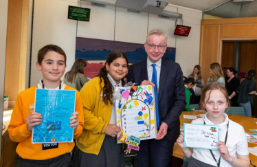 Pictured, Michael Gove MP with pupils from Holy Trinity Church of England Primary School